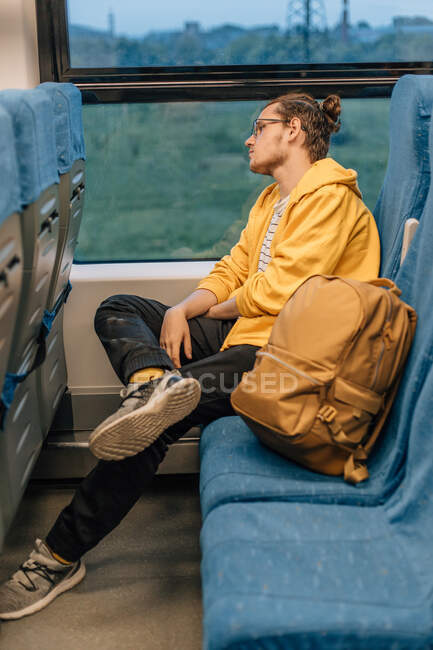 Jovem adolescente com óculos viaja em trem com mochila, transporte público. Tiro vertical, retrato de close-up. — Fotografia de Stock