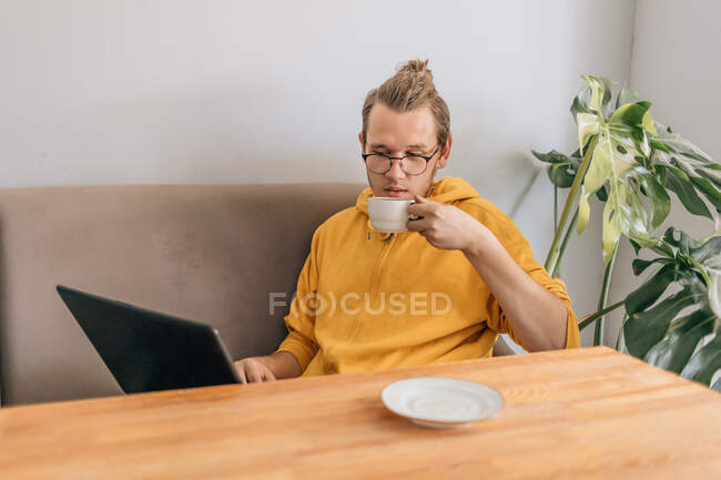 Teenager young man drinking coffee in cafe. Lifestyle shot with copy space. — Stock Photo