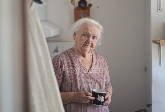 Portrait of elderly lady in her kitchen — Stock Photo