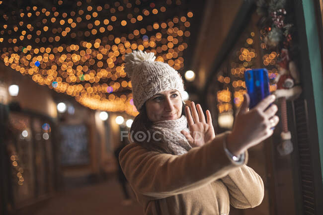 Woman walk and take a live broadcast to the social media during Christmas time — Stock Photo