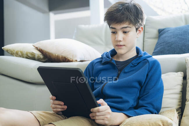 O menino usando tablet para comunicação on-line em casa — Fotografia de Stock