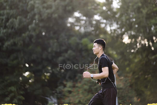 Спортивний молодий чоловік біжить на природі. Здоровий спосіб життя — стокове фото