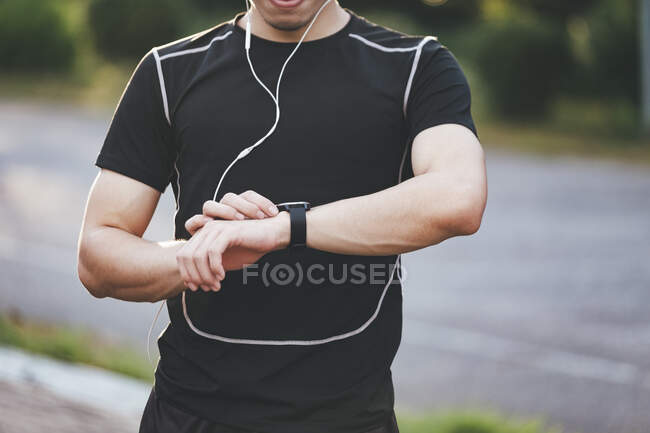 Спортивний бігун починає тренування з трекера фітнесу або розумного годинника . — стокове фото