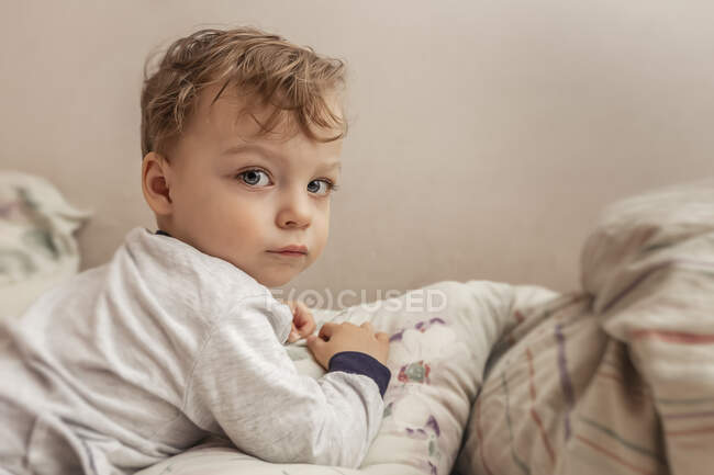 Portrait d'un tout-petit couché sur une couverture en pyjama — Photo de stock