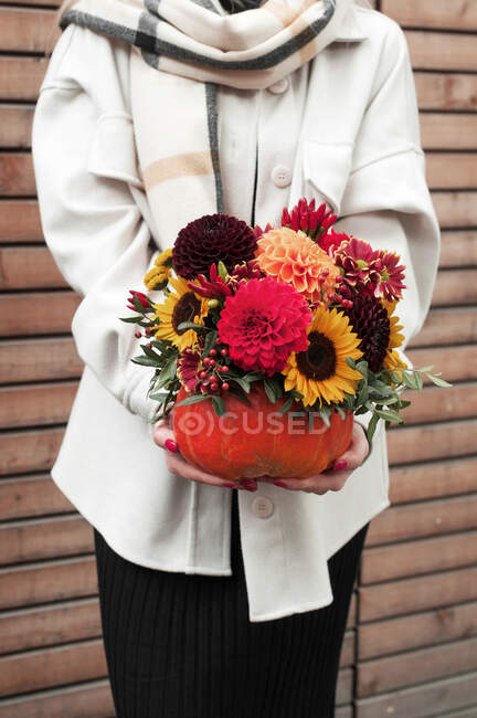 Beautiful young woman with bouquet of flowers in hands — Stock Photo