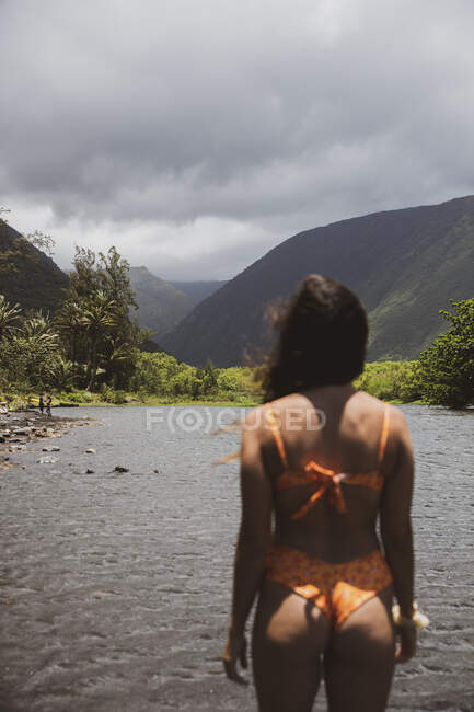 Женщина в черном купальнике стоит на пляже — стоковое фото