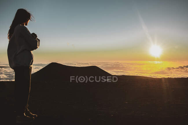 Silhouette di una donna con uno zaino sullo sfondo delle montagne — Foto stock