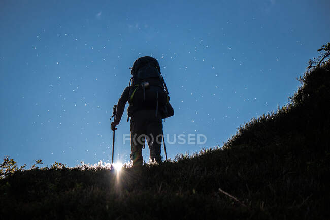 Silhouette di un uomo con zaino escursionismo in montagna — Foto stock