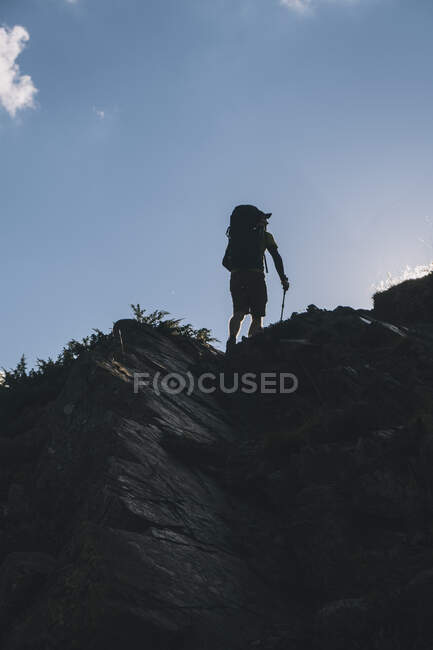Вид сзади на молодого туриста, поднимающегося на горный хребет в Пиренеях, Арагон, Испания — стоковое фото
