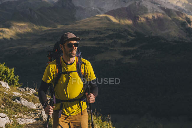 Happy man wearing a backpack hiking by the Pyrenees mountains, Aragon Spain — Stock Photo
