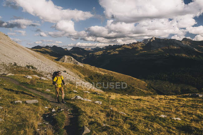 Hombre feliz con una mochila de senderismo por las montañas del Pirineo, Aragón España - foto de stock
