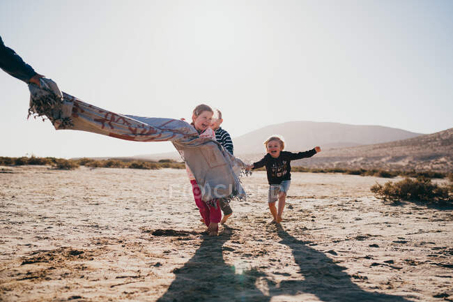 Niños pequeños jugando en la arena en la playa - foto de stock