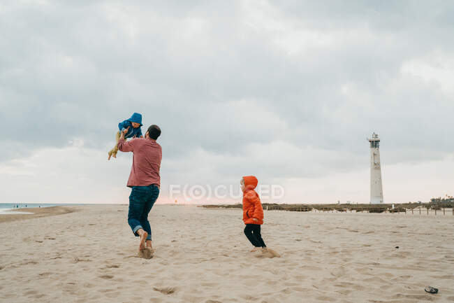 Niños pequeños jugando en la arena en la playa - foto de stock