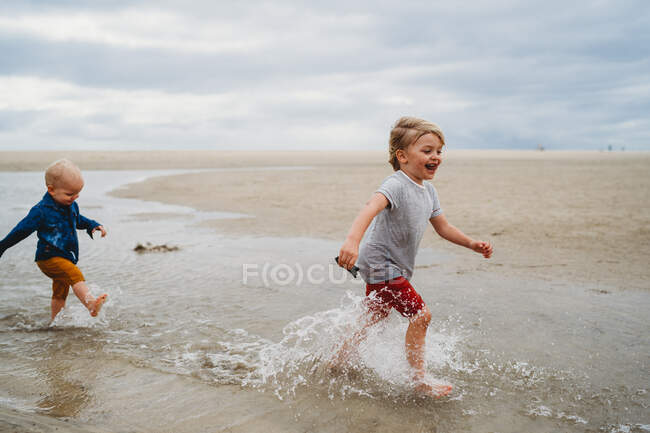 Petits enfants jouant sur le sable sur la plage — Photo de stock