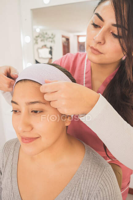 Jovem mulher se preparando para colocar maquiagem para um evento especial. Em um centro de maquiagem aproveitando este dia. — Fotografia de Stock