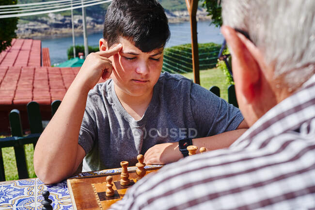 Avô e neto jogando xadrez no jardim — Fotografia de Stock