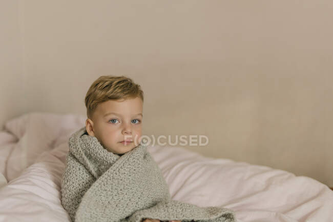 Маленький мальчик лежит на кровати — стоковое фото