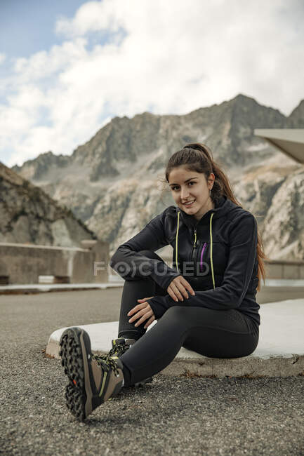 Young woman sitting on the ground and looking at the camera — Stock Photo