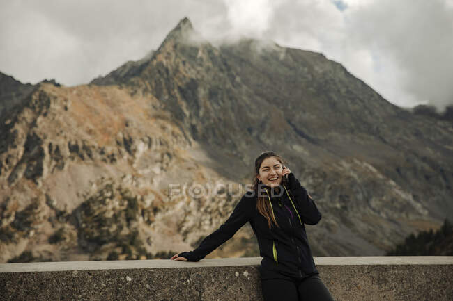 Mujer joven tomando fotos con smartphone en las montañas - foto de stock