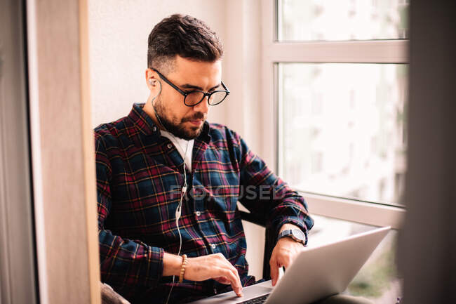 Людина використовує ноутбук під час роботи вдома — стокове фото