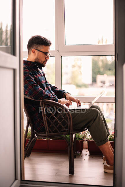 Homem usando computador portátil enquanto trabalhava em casa — Fotografia de Stock