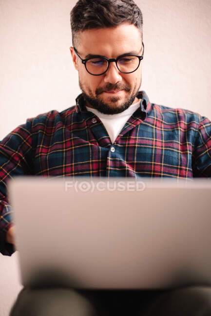 Homem feliz usando computador portátil em casa — Fotografia de Stock