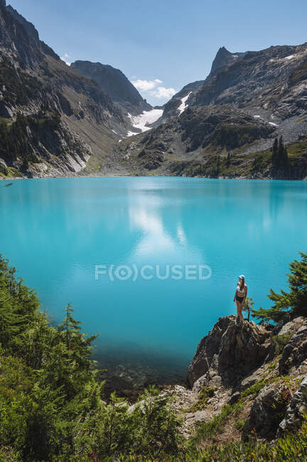 Belle femme dans une veste verte et lac bleu — Photo de stock