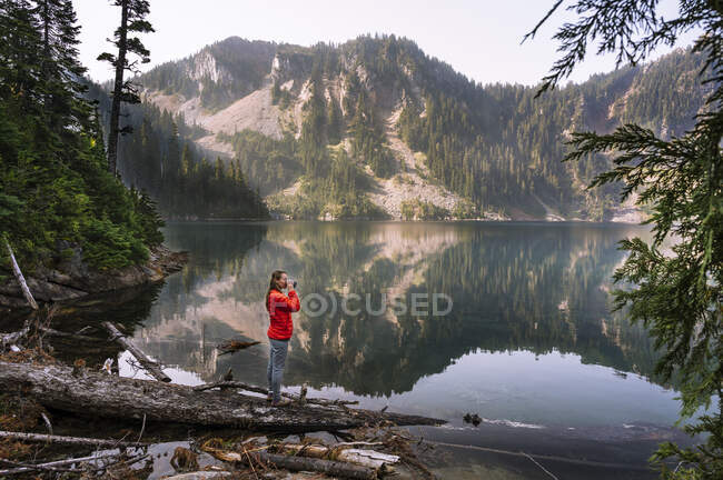 Mulher de pé na borda do lago — Fotografia de Stock