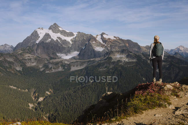 Randonneur avec sac à dos et une montagne en arrière-plan — Photo de stock