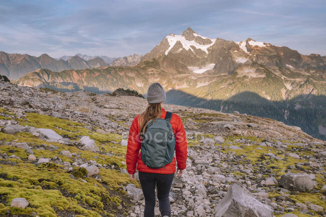 Mulher caminhante com mochila caminhadas nas montanhas — Fotografia de Stock