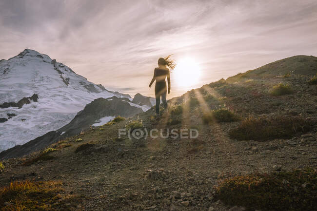 Mujer joven de pie en la cima de la montaña. - foto de stock