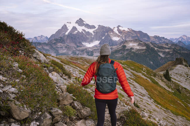 Woman with backpack hiking in the mountains — Stock Photo
