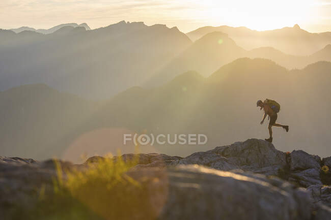 Hombre con mochila senderismo en las montañas - foto de stock