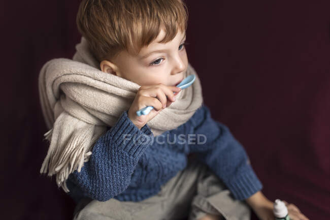 Enfermo niño pequeño en bufanda de lana y suéter tomando en la medicación fr - foto de stock
