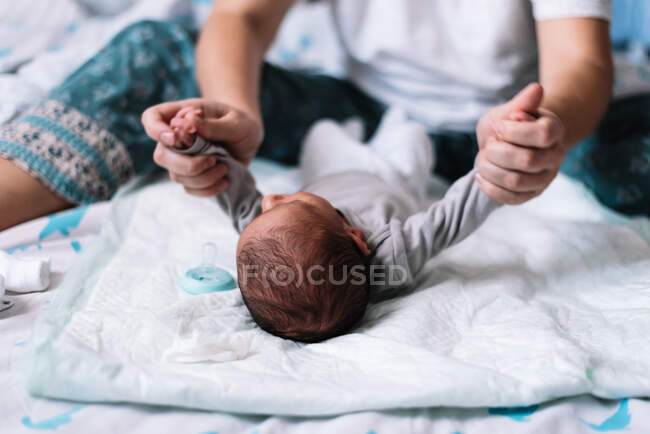 Mother exercising her baby's arms. — Stock Photo