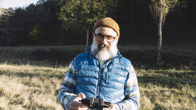 Retrato de un hombre operando el mando a distancia de un dron. - foto de stock