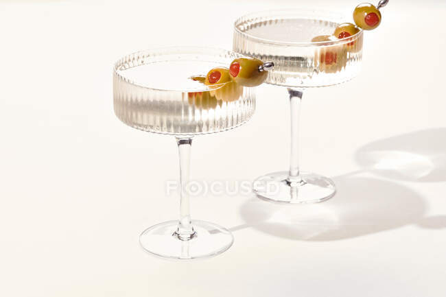 Дві горілки або джин мартіні плавають оливки на білому тлі — стокове фото