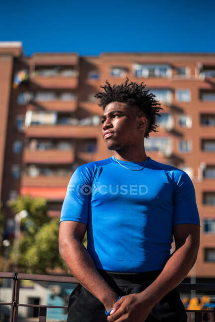 Portrait of young athletic black man. Tower of apartments background. — Stock Photo