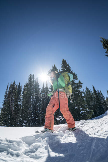 Homem com mochila na neve nas montanhas — Fotografia de Stock