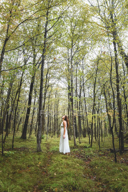 Schöne junge Frau in einem weißen Kleid im Park — Stockfoto