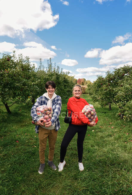 Young couple with apples in the park — Stock Photo