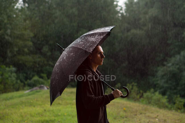 Молода жінка з парасолькою в парку — стокове фото