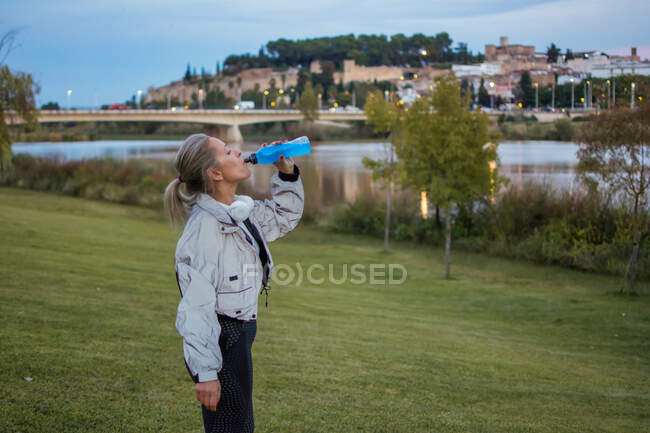 Young woman with binoculars on the background of the river — Stock Photo