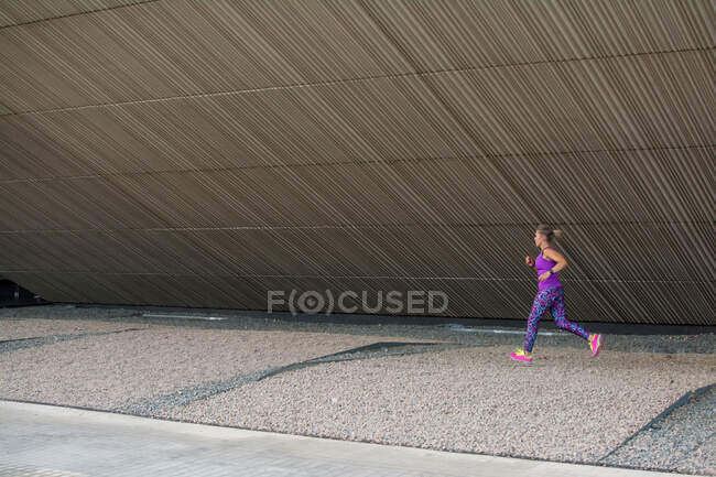 Mujer joven corriendo en la calle - foto de stock