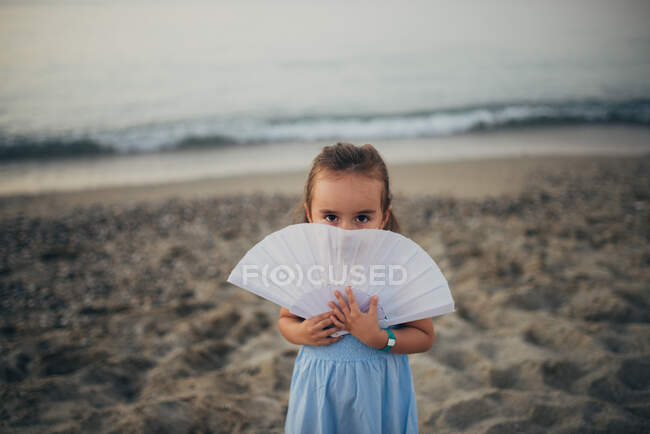 Little girl with a seashell on the beach — Stock Photo