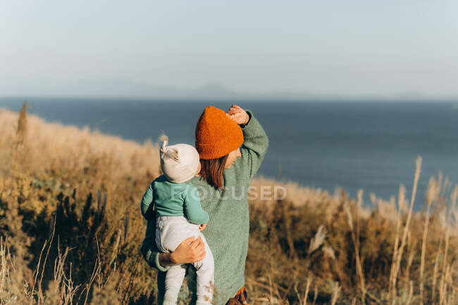 Young mother with her little daughter on the beach — Stock Photo