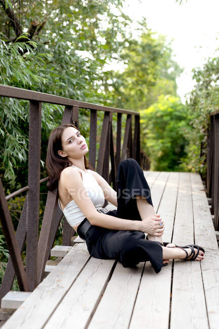 Schöne junge Frau sitzt auf der Bank im Park — Stockfoto