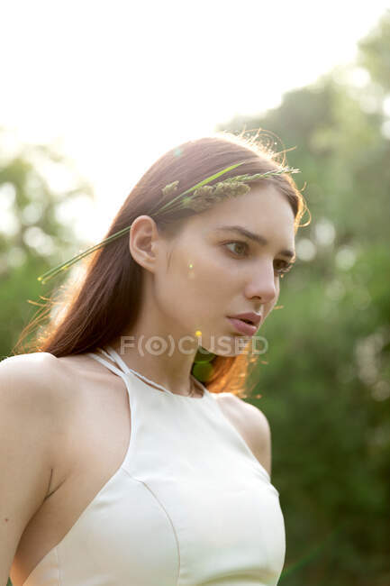 Junge schöne Frau im weißen Kleid posiert im Park — Stockfoto