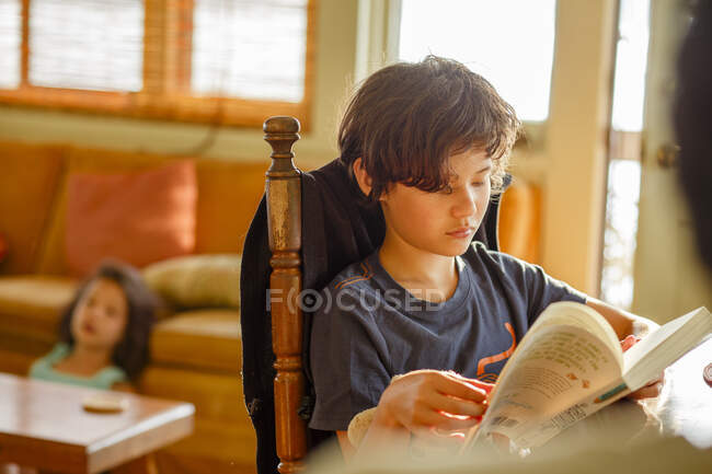Menino leitura livro em casa — Fotografia de Stock
