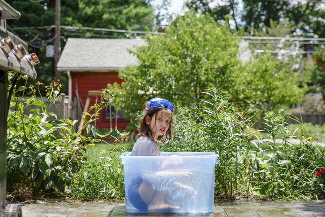 Маленькая девочка в синем платье с корзиной воды — стоковое фото